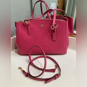 Coach crossbody handbag with long strap and gold hardware.